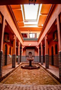 an empty room with a fountain in the middle of a building at Hôtel LAKASBAH Ait Ben Haddou in Aït Ben Haddou