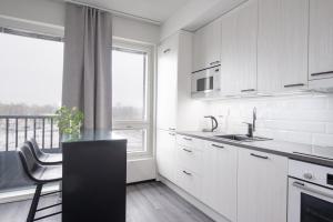 a kitchen with white cabinets and a black counter top at Rauma City Center Studios in Rauma