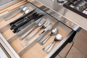 a drawer with silver utensils in a kitchen at Al Platano Orientale in Bologna
