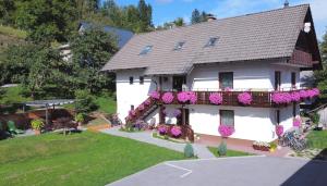 ein Haus mit Blumen auf der Seite in der Unterkunft Apartments Lake Bohinj Medja in Bohinj