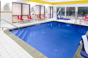 a pool in a hotel room with red chairs at Courtyard Bethlehem Lehigh Valley/I-78 in Bethlehem