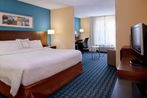 a hotel room with a bed and a flat screen tv at Fairfield Inn by Marriott Kalamazoo West in Kalamazoo