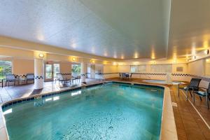 a pool in a hotel with chairs and tables at Fairfield Inn Battle Creek in Battle Creek