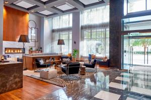 a lobby with couches and chairs and a lobby with windows at Renaissance Atlanta Midtown Hotel in Atlanta