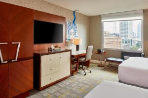 a hotel room with a bed and a desk with a television at Renaissance Atlanta Midtown Hotel in Atlanta