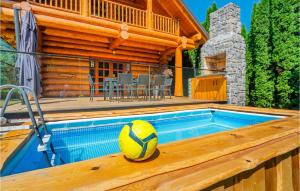 a pool with a volleyball ball sitting on a wooden deck at Cozy Home In Brod Na Kupi With Kitchen in Brod na Kupi
