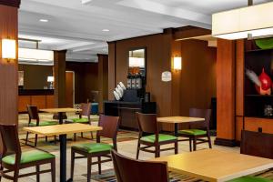 a restaurant with wooden tables and green chairs at Fairfield by Marriott Inn and Suites Augusta Fort Eisenhower Area in Augusta
