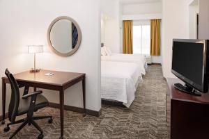a hotel room with a desk and a bed and a television at SpringHill Suites by Marriott Ardmore in Ardmore