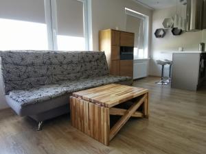 a living room with a couch and a coffee table at SUNSET Apartment - Brand new, Family friendly in Ventspils