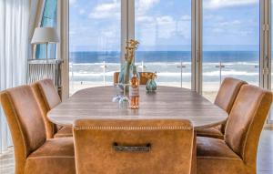 a dining room table with leather chairs and a view of the ocean at Appartement Shrimp in Egmond aan Zee