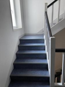 a stair case with blue stairs with a window at L améthystes in Crozon