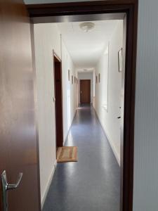 an empty hallway with a hallway leading into a room at L améthystes in Crozon