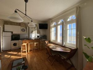 a kitchen and living room with a table and chairs at L améthystes in Crozon