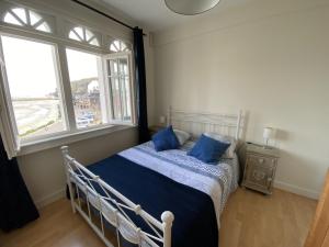 a bedroom with a bed with blue pillows and a window at L améthystes in Crozon