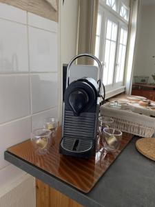 a black toaster sitting on a counter with glasses on it at L améthystes in Crozon