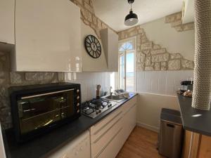 a kitchen with a stove and a clock on the wall at L améthystes in Crozon