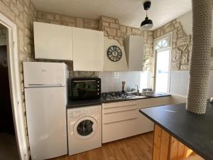 a kitchen with a white refrigerator and a dishwasher at L améthystes in Crozon