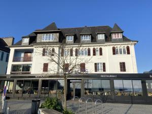 a large white building with a store front at L améthystes in Crozon