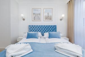 a blue and white bedroom with a large bed at Jantar Apartamenty Kołobrzeg - Cosy Apartment in Kołobrzeg