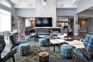 um átrio do hotel com mesas de cadeiras e uma lareira em Residence Inn by Marriott Bakersfield West em Bakersfield
