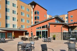 a courtyard with tables and chairs in front of a building at Residence Inn by Marriott Bakersfield West in Bakersfield