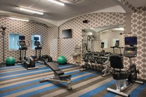 einen Fitnessraum mit mehreren Laufbändern und einem Spiegel in der Unterkunft Aloft Buffalo Downtown in Buffalo