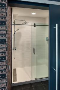 a shower with a glass door in a bathroom at Aloft Buffalo Downtown in Buffalo