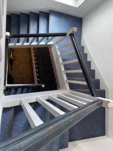 a staircase in a building with blue walls at L améthystes in Crozon