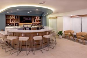 a lobby with a bar with white stools at Element Chelmsford in Chelmsford