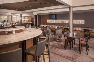 a restaurant with tables and chairs and a bar at Courtyard By Marriott Baltimore BWI Airport in Linthicum Heights
