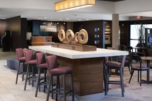 アルバカーキにあるCourtyard by Marriott Albuquerque Airportのピンクのスツールが備わるレストランのバー