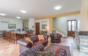 ein Wohnzimmer mit Ledersofas und ein Esszimmer in der Unterkunft Awesome Home In Torchiara With Private Swimming Pool, Can Be Inside Or Outside in Torchiara