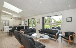 a living room with black leather furniture and a kitchen at Stunning Home In Vggerlse With Wifi in Marielyst