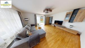 a living room with a couch and a flat screen tv at Apartment Brigitte Schöndorfer in Strobl