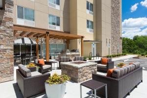 un patio avec des chaises et un foyer extérieur en face d'un bâtiment dans l'établissement TownePlace Suites Boone, à Boone