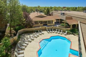 einen Blick über einen Pool mit Liegestühlen und ein Resort in der Unterkunft Fort Collins Marriott in Fort Collins