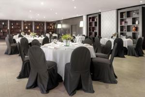 a conference room with white tables and black chairs at AC Hotel Elda by Marriott in Elda