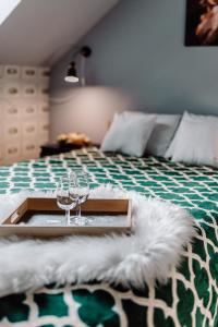 a tray with wine glasses on top of a bed at Domki RADAWA na Kliszówce in Radawa