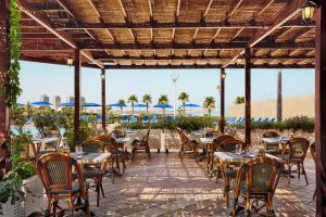 een patio met tafels, stoelen en parasols bij Sheraton Club des Pins Resort in Club des Pins