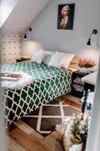 a bedroom with a bed with a green and white comforter at Domki RADAWA na Kliszówce in Radawa