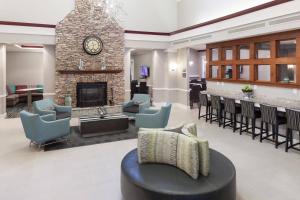 a lobby with a fireplace and chairs and a table at Residence Inn Boston Marlborough in Marlborough