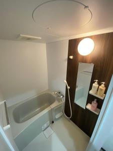 a bathroom with a bath tub and a mirror at shizuka1 501 in Osaka