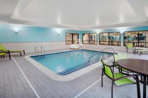 - une piscine dans un hôtel avec des tables et des chaises dans l'établissement SpringHill Suites Hartford Airport/Windsor Locks, à Windsor Locks