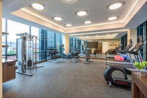 a gym with cardio equipment in a building with windows at Courtyard by Marriott Bogota Airport in Bogotá
