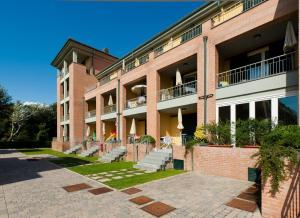Un grand bâtiment en briques avec des escaliers se trouve juste devant. dans l'établissement Continental Resort, à Tirrenia