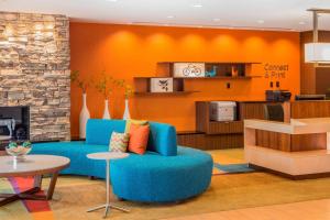 een woonkamer met een blauwe bank en een keuken bij Fairfield Inn & Suites by Marriott Waterloo Cedar Falls in Waterloo