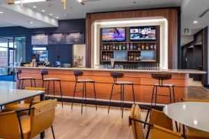 a bar in a restaurant with tables and stools at Courtyard by Marriott Conway in Conway