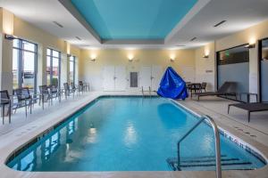 a swimming pool with chairs and a blue ceiling at Courtyard by Marriott Conway in Conway