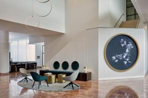 バーゼルにあるBasel Marriott Hotelの椅子と壁画のあるロビー