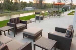 un patio con sillas, mesas, mesas y sillas en TownePlace Suites by Marriott Battle Creek, en Battle Creek